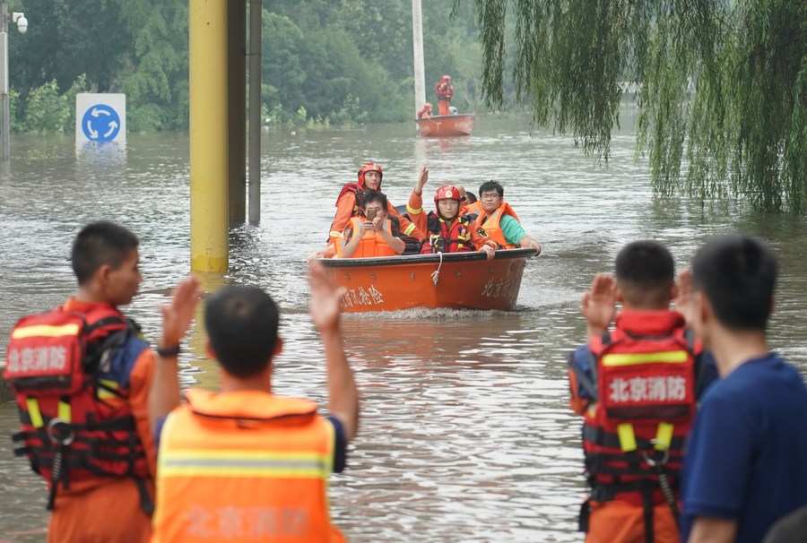 Rescatistas transportan personas a un punto de transbordo en el distrito de Fangshan de Beijing, la capital de China, el 2 de agosto de 2023. (Xinhua/Ren Chao)