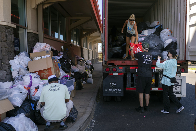 Voluntarios descargan donaciones en un centro de distribución para los afectados por los incendios de Maui en Parque de la Playa Honokawai en Napili-Honokowai, Maui, Hawai, 14 de agosto del 2023. [Foto: VCG]