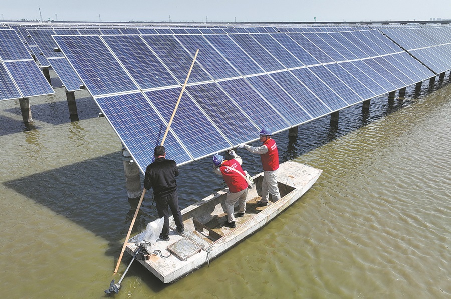 Electricistas revisan paneles fotovoltaicos en una central eléctrica fotovoltaica situada en un lago en Lianyungang, provincia de Jiangsu, en abril. [Foto de Si Wei/Para China Daily]