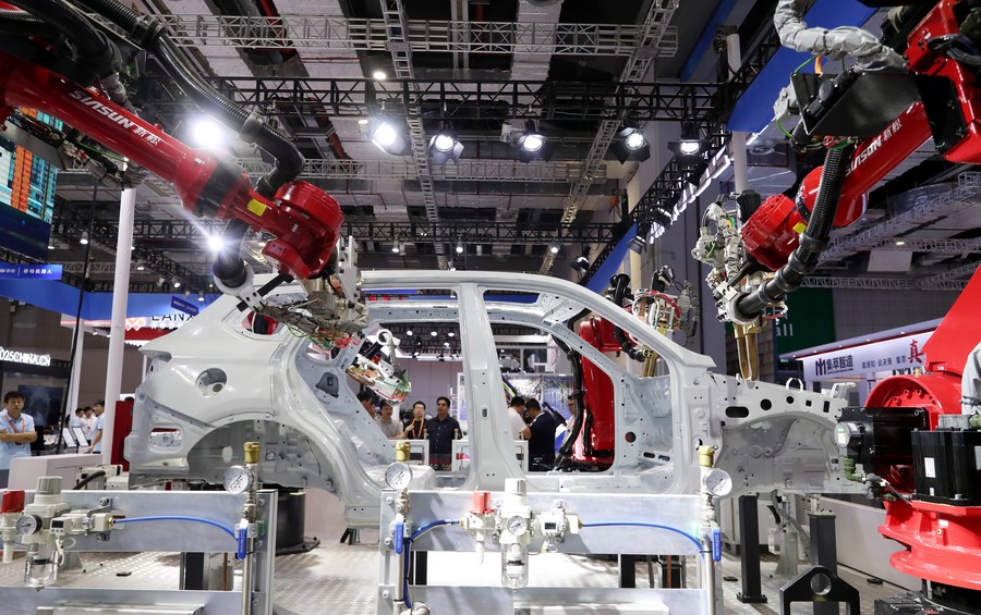 Visitantes observan un robot diseñado para soldar carrocerías durante la 23ª Feria Internacional de la Industria de China (CIIF, por sus siglas en inglés) en Shanghai, al este de China, el 19 de septiembre de 2023. (Xinhua/Fang Zhe)