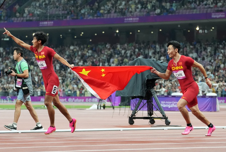 Chen Jiapeng (i), y Chen Guanfeng, del equipo de China, festejan después de la final masculina de relevos 4 x 100m de Atletismo en los XIX Juegos Asiáticos, en Hangzhou, en la provincia de Zhejiang, en el este de China, el 3 de octubre de 2023. (Xinhua/Sun Fei)