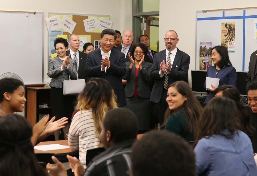 Xi Jinping (4-i-atrás) y su esposa Peng Liyuan (2-i-atrás) saludan a maestros y estudiantes durante su visita a la Escuela Secundaria Lincoln en Tacoma, en el Estado de Washington, Estados Unidos, el 23 de septiembre de 2015. (Xinhua/Lan Hongguang) 