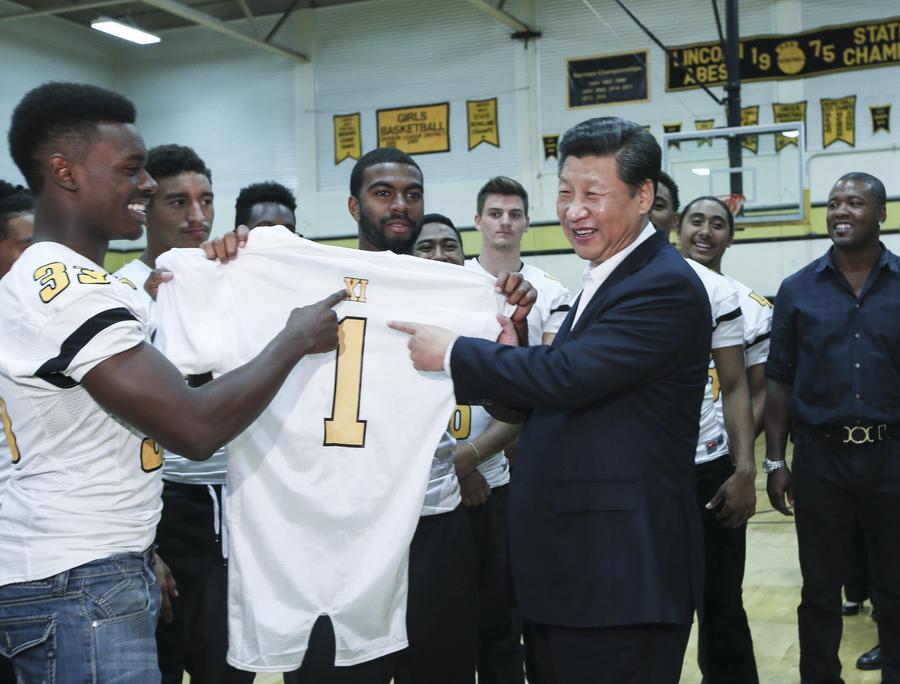 Xi Jinping (d-frente), recibe una camiseta del equipo estudiantil de rugby durante su visita a la Escuela Secundaria Lincoln, en Tacoma, en el Estado de Washington, Estados Unidos, el 23 de septiembre de 2015. (Xinhua/Lan Hongguang) 
