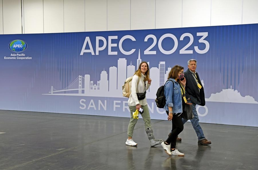 Imagen del 12 de noviembre de 2023 de representantes de los medios de comunicación caminando frente a un cartel en el centro internacional de medios de la APEC 2023, en San Francisco, Estados Unidos. (Xinhua/Li Rui)