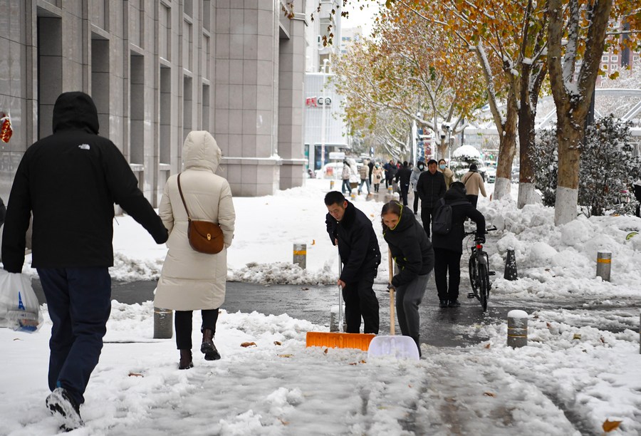 Dos personas limpian una acera después de una nevada, en Zhengzhou, capital de la provincia central china de Henan, el 11 de diciembre de 2023. (Xinhua/Hao Yuan)