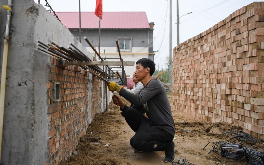 Trabajadores reconstruyen un edificio deteriorado en la aldea Shanjuzhuang de la ciudad de Gaobeidian, en la provincia septentrional china de Hebei, el 27 de septiembre de 2023. (Xinhua/Mu Yu)