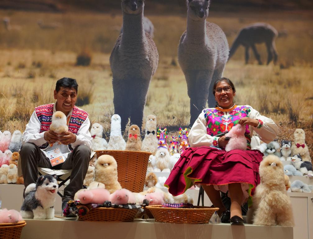 Oswaldo y Gloria, un matrimonio de artesanos de Perú, exhiben sus peluches de alpaca en el estand de la empresa Warmpaca, durante la sexta edición de la Exposición Internacional de Importaciones de China, en la metrópoli oriental china de Shanghai, el 5 de noviembre de 2023. (Xinhua/Sergio Gómez)