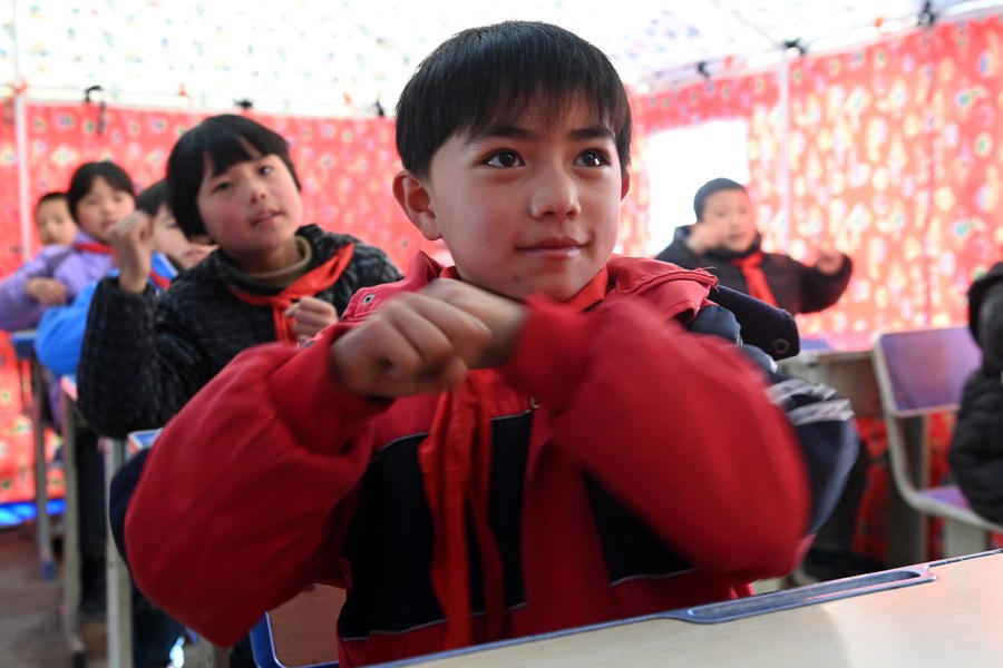 Estudiantes asisten a clase en un aula temporal en la ciudad de Liugou, en el distrito autónomo de Bonan-Dongxiang-Salar de Jishishan, provincia de Gansu, en el noroeste de China, el 27 de diciembre de 2023. (Xinhua/Fan Peishen)