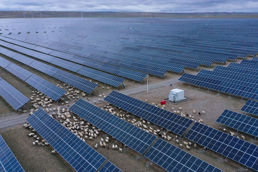 Vista aérea de ovejas caminando a través de una estación de energía fotovoltaica en el distrito de Gonghe de la prefectura autónoma tibetana de Hainan, provincia de Qinghai, en el noroeste de China, el 9 de junio de 2022. (Xinhua/Zhang Long)