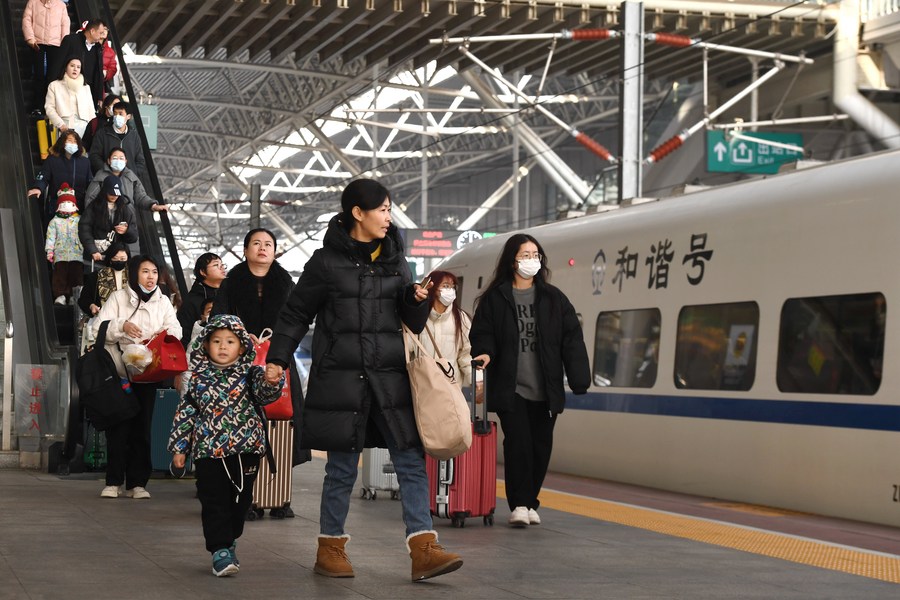 Viajeros toman un tren en la estación de tren de Nanjing, capital de la provincia de Jiangsu, en el este de China, el 1 de enero de 2024. (Foto de Yang Suping/Xinhua)