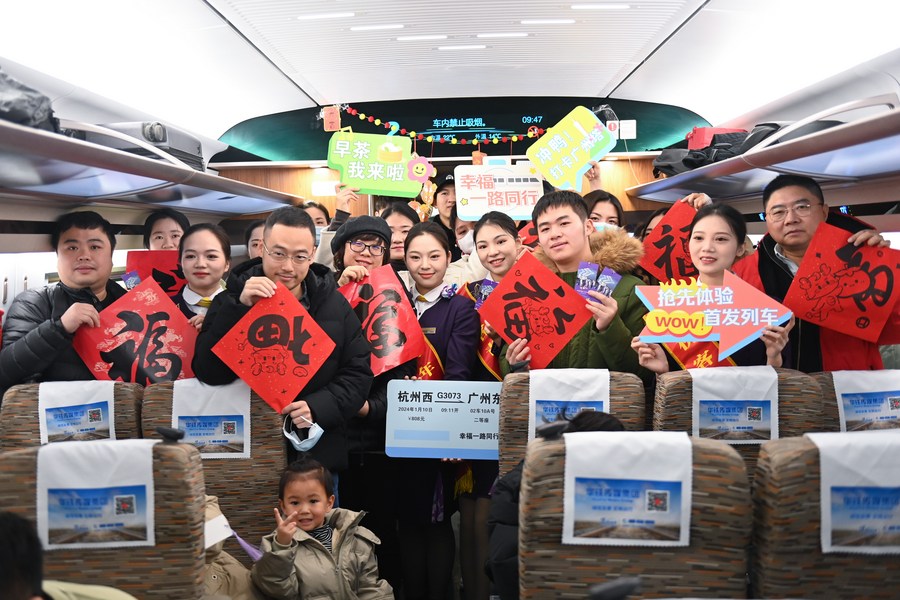 Pasajeros y empleados posan para una foto grupal en el primer tren bala que viaja directamente a la estación ferroviaria de Guangzhou Este, en la provincia meridional china de Guangdong, desde la estación de Hangzhou Oeste, en la ciudad de Hangzhou, en la provincia oriental de Zhejiang, el 10 de enero de 2024. (Xinhua/Huang Zongzhi)