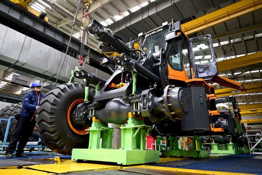 Un empleado trabaja en una línea de montaje de montacargas de una filial de la multinacional de maquinaria pesada Develon en Yantai, ciudad de la provincia oriental china de Shandong, el 26 de diciembre de 2023. (Xinhua/Guo Xulei)