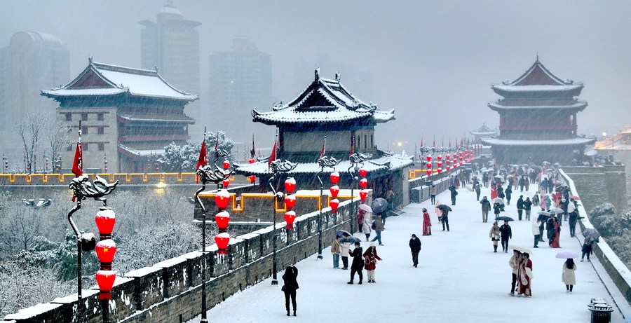 Vista aérea tomada con un dron el 16 de enero de 2024 de turistas visitando la antigua muralla de la ciudad cubierta de nieve, en Xi'an, en la provincia de Shaanxi, en el noroeste de China. (Xinhua/Liu Xiao)