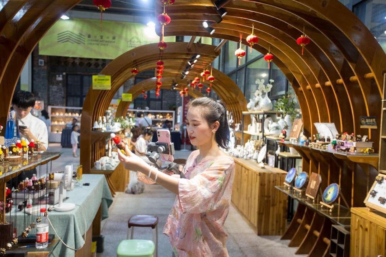 Una mujer exhibe productos de porcelana durante una sesión de transmisión en vivo en un bloque cultural y creativo en Jingdezhen, provincia de Jiangxi. (Foto: Zhai Huiyong/ Diario del Pueblo digital)