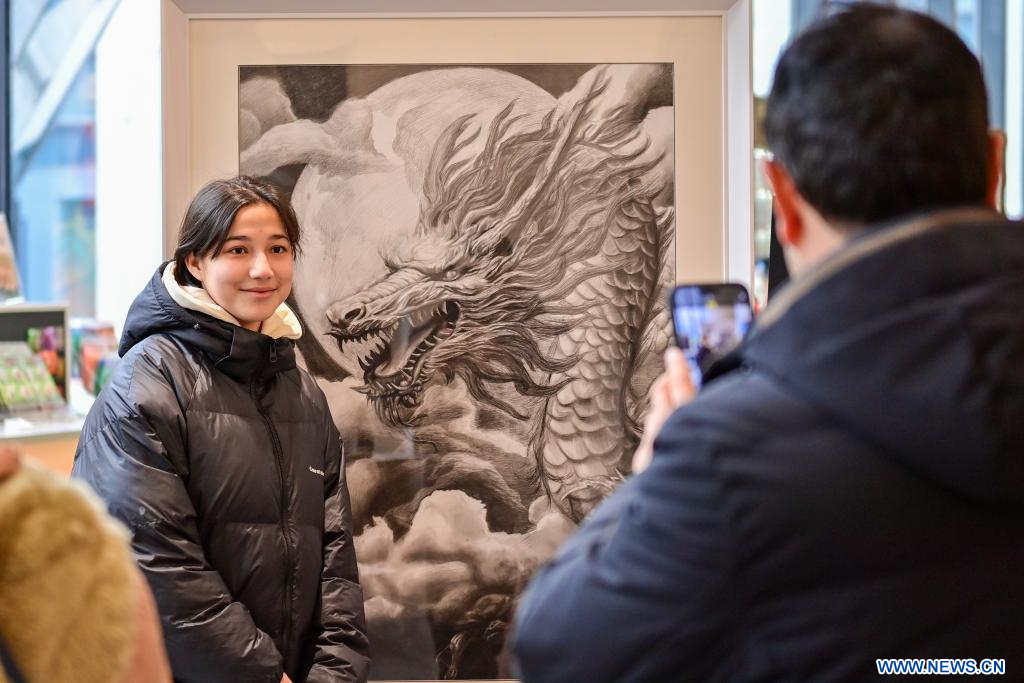 Una visitante posa para una fotografía con una exhibición en un museo, en Urumqi, capital de la región autónoma uygur de Xinjiang, en el noroeste de China, el 14 de febrero de 2024. Muchas personas optan por pasar sus vacaciones del Festival de la Primavera observando exhibiciones en museos. (Xinhua/Ding Lei)