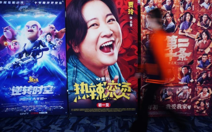 Un ciudadano camina frente a carteles de promoción de películas en un cine en la ciudad de Hangzhou, capital de la provincia de Zhejiang, en el este de China, el 16 de febrero de 2024. (Xinhua/Long Wei)