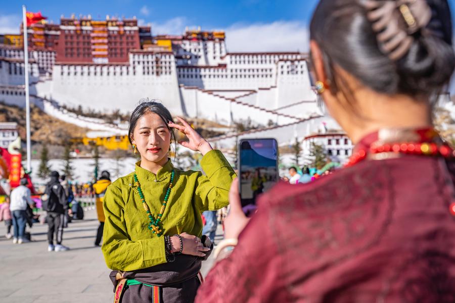 Una turista posa para una foto frente al Palacio de Potala en Lhasa, capital de la región autónoma de Xizang, en el suroeste de China, el 11 de febrero de 2024. (Xinhua/Sun Fei)