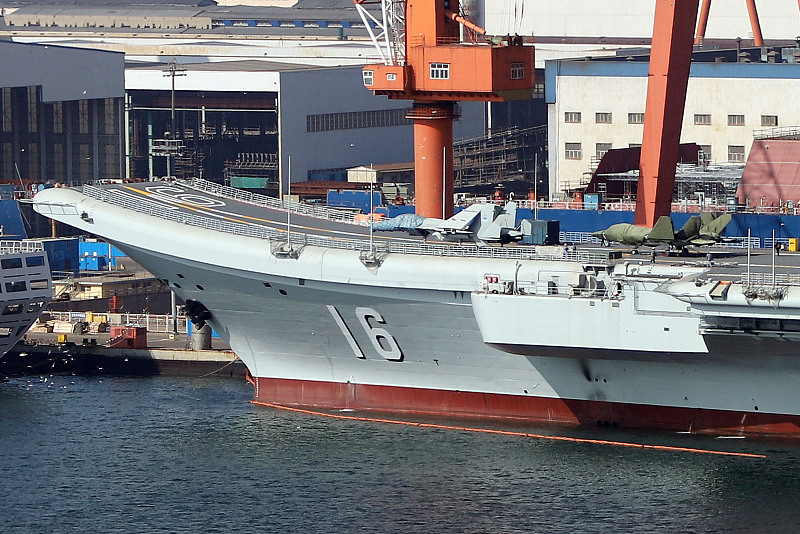 Cubiertos de tela impermeable, los modelos a escala real de un caza furtivo supuestamente llamado J-35 (derecha) y un caza J-15 a la vista en la cubierta del portaaviones Liaoning en el astillero de Dalian, provincia nororiental china de Liaoning, a mediados de febrero de 2024. [Foto: VCG]