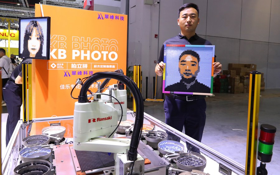 Un trabajador muestra su retrato hecho en bloques durante la 23ª Feria Internacional de la Industria de China (CIIF, por sus siglas en inglés), en Shanghai, en el este de China, el 19 de septiembre de 2023. (Xinhua/Fang Zhe)