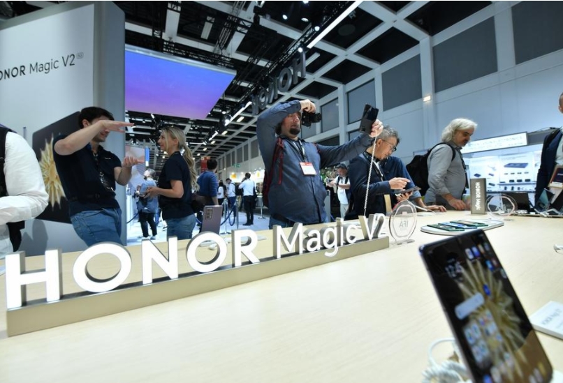 Varias personas prueban teléfonos plegables en el estand de la compañía china Honor durante la exposición IFA 2023 en Berlín, la capital de Alemania, el 1 de septiembre de 2023. (Xinhua/Ren Pengfei)