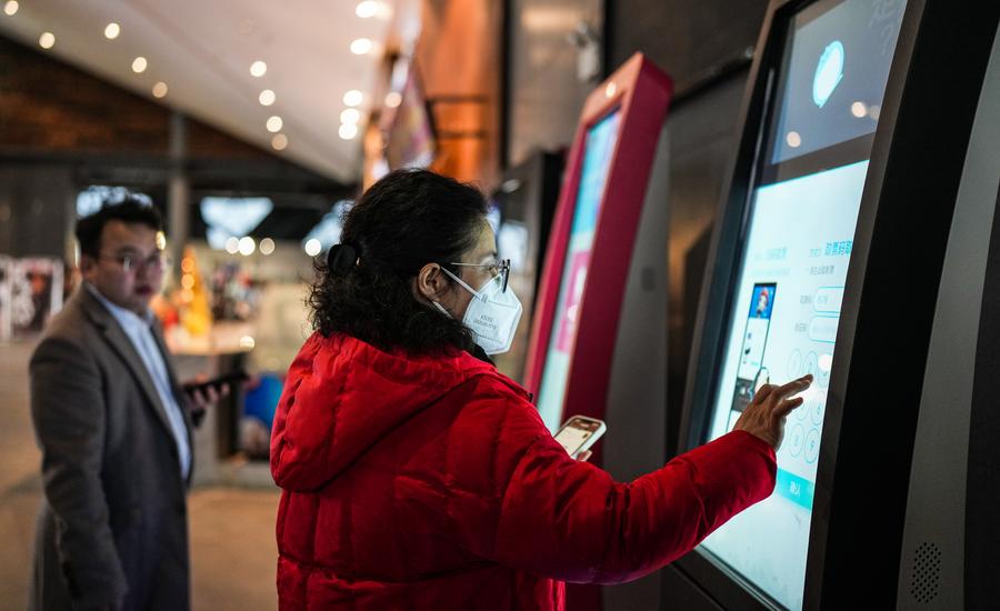 Una clienta obtiene entradas en una máquina de autoservicio en un cine de Guiyang, en la provincia suroccidental china de Guizhou, el 29 de enero de 2023. (Xinhua/Tao Liang)