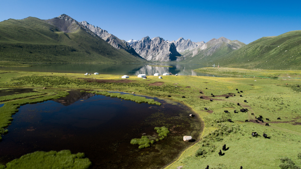 Una foto aérea muestra el paisaje en el monte Nyanpo Yutse, en la prefectura autónoma tibetana de Golog, en la provincia noroccidental china de Qinghai. La provincia de Qinghai, ubicada en el noroeste de China, gran parte de la cual se encuentra en la meseta Qinghai-Tíbet, es el hogar de nacimiento de los ríos Yangtsé, Amarillo y Lancang. [Foto/Xinhua]