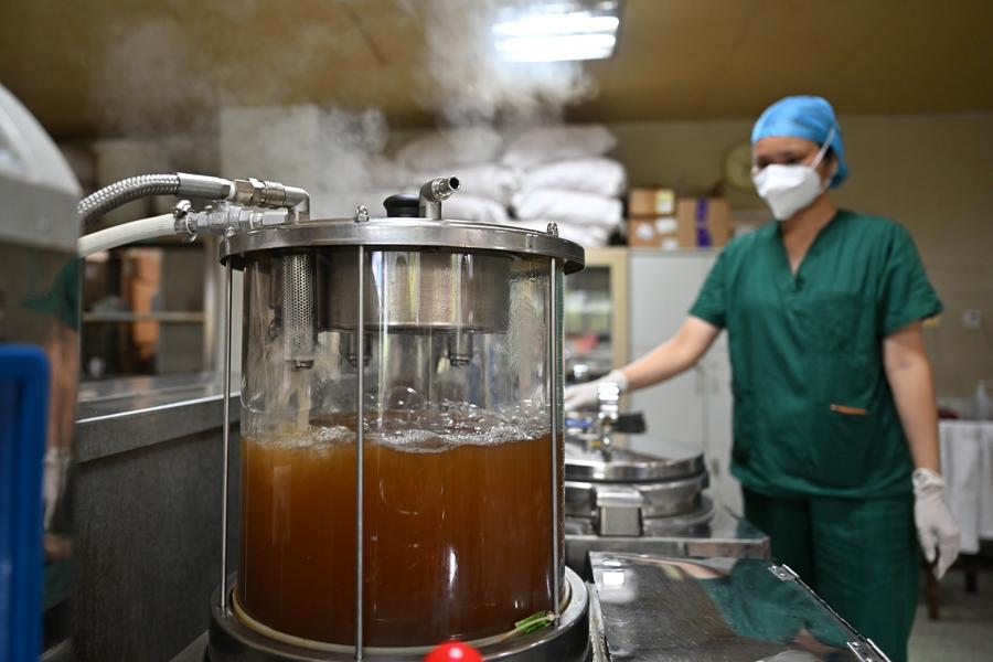 A pharmacist prepares a traditional Chinese medicine (TCM) decoction at the Sanya City Traditional Chinese Medicine Hospital in Sanya, south China's Hainan province, on Aug. 20, 2022, in China.  (Xinhua Guo Cheng)