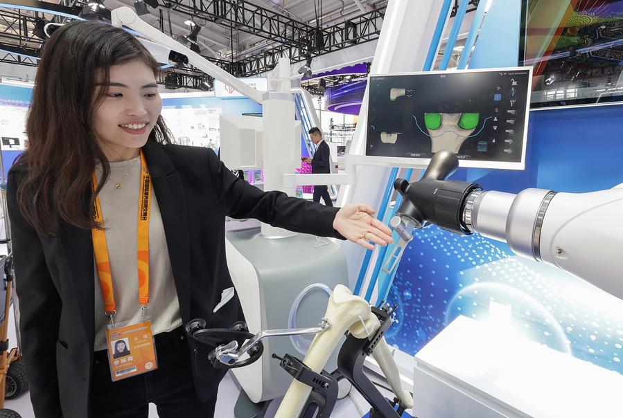 Una integrante del equipo de trabajo presenta un robot utilizado en cirugías de articulación de rodilla en el stand del Peking Union Medical College Hospital en el área de exposición de servicios de salud de la Feria Internacional de Comercio de Servicios de China (CIFTIS, siglas en inglés) 2023 organizada en el parque Shougang, en Beijing, capital de China, el 4 de septiembre de 2023. (Xinhua/Zhang Yuwei)