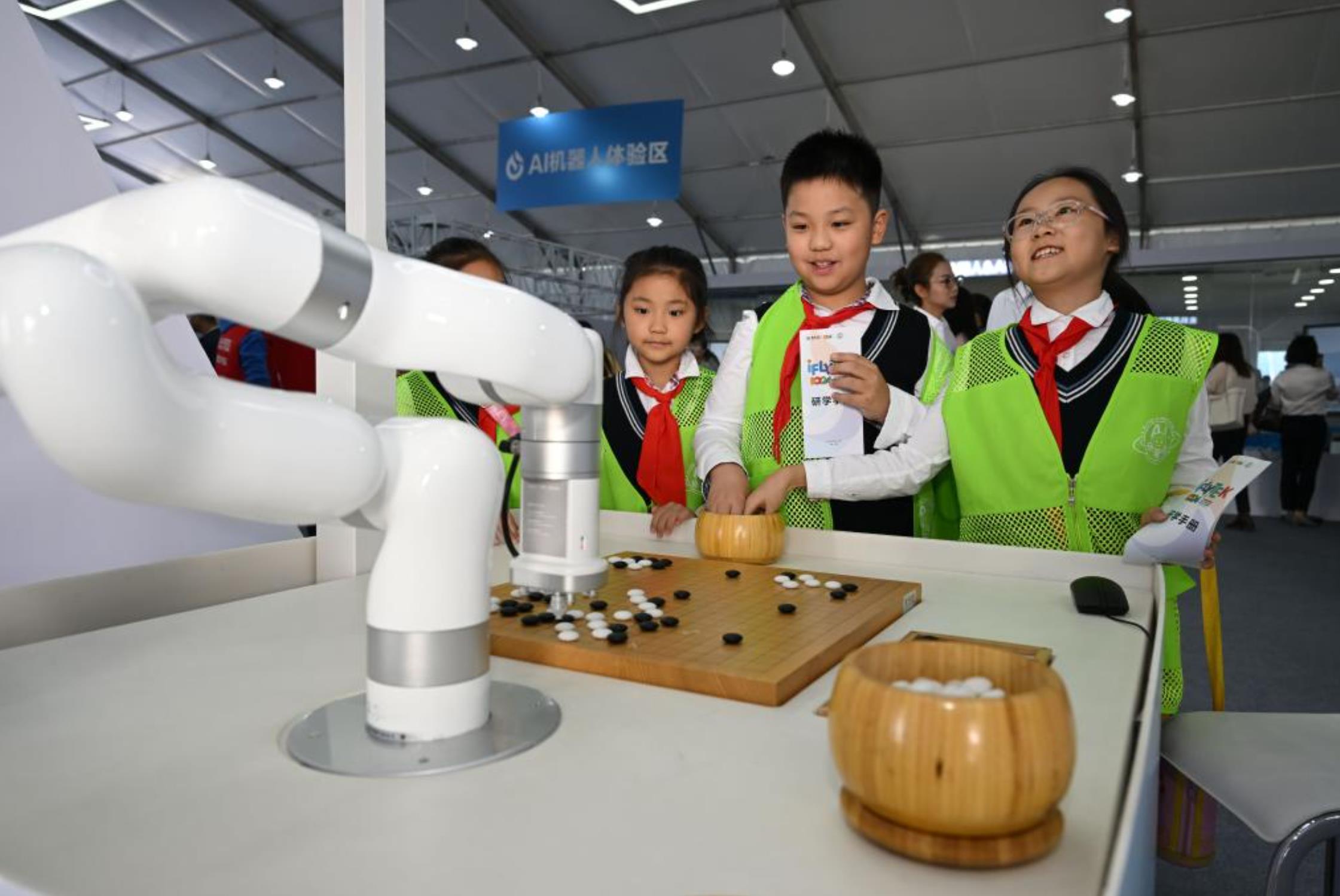 Alumnos juegan al go con un robot en la XI Feria Mundial del Sonido en la ciudad de Hefei, capital de la provincia de Anhui, en el este de China, el 24 de octubre de 2023. (Xinhua/Zhou Mu) 