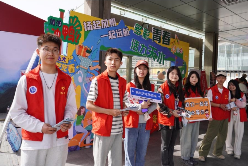 Un grupo de voluntarios saluda a los turistas en la estación ferroviaria de Tianshui Sur, en la ciudad de Tianshui de la provincia noroccidental china de Gansu, el 3 de abril de 2024. (Xinhua/Ma Xiping)