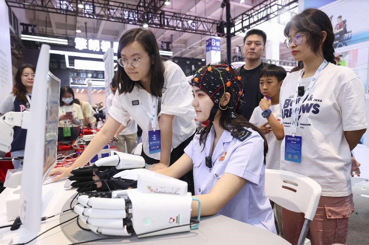 Una chica experimenta una interfaz cerebro-computadora inteligente (BCI) en la Conferencia Mundial de Robots 2023 en Beijing, el 21 de agosto de 2023. (Foto de Chen Xiaogen/ Diario del Pueblo digital)