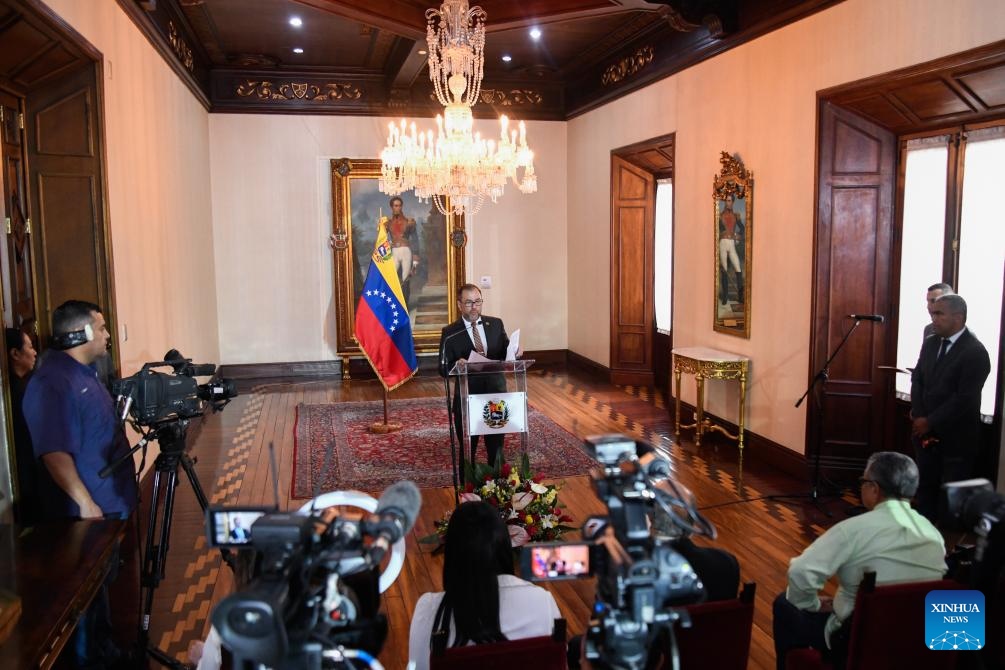 El canciller venezolano Yván Gil (c-atrás), habla durante una conferencia de prensa, en Caracas, Venezuela, el 18 de abril de 2024. El Gobierno de Venezuela reiteró el jueves su rechazo a "la pretensión del gobierno de Estados Unidos de monitorear, tutelar, controlar y manipular la industria petrolera venezolana", según un comunicado leído por el canciller Yván Gil. (Xinhua/Marcos Salgado) 