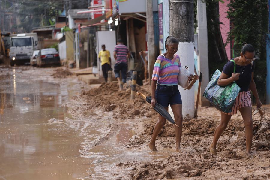 Mujeres caminan en una calle embarrada tras las lluvias, en Barra do Sahy, en el municipio de Sao Sebastiao, en el estado de Sao Paulo, Brasil, el 21 de febrero de 2023. (Xinhua/Rahel Patrasso)