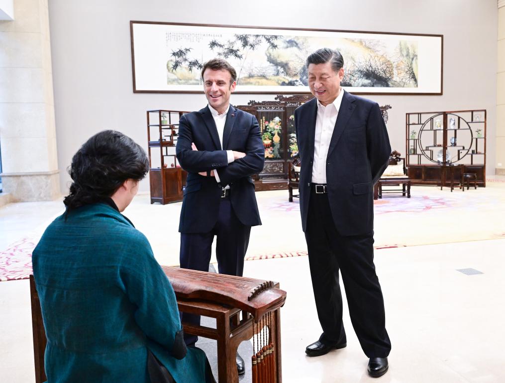El presidente chino, Xi Jinping, y el presidente francés, Emmanuel Macron, escuchan la melodía para qin La alta montaña y el agua que corre en la Sala Baiyun del Jardín de los Pinos, en Guangzhou, en la provincia meridional china de Guangdong, el 7 de abril de 2023. (Xinhua/Yue Yuewei)
