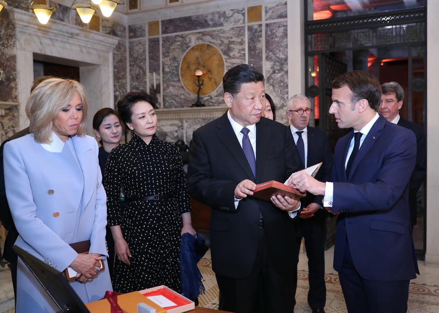 El presidente chino, Xi Jinping (2-d-frente), recibe la versión original francesa de Introducción a las Analectas de Confucio, publicada en 1688, de manos de su homólogo francés, Emmanuel Macron (1-d-frente), como regalo nacional antes de su reunión en Niza, Francia, el 24 de marzo de 2019. (Xinhua/Ju Peng)