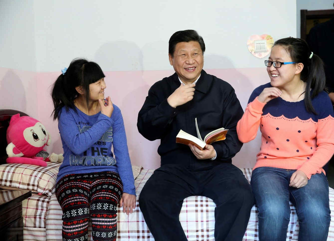 El 28 de enero de 2014, Xi Jinping alentó a la niña sordomuda Wang Yani (izquierda) y a la estudiante universitaria Yan Zhijing a estudiar mucho y lograr el éxito académico en el dormitorio del Instituto de Bienestar Infantil de Hohhot. Foto de Lan Hongguang