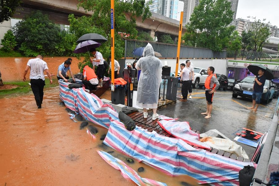 Voluntarios colocan sacos de arena para el control de inundaciones en la entrada de un garaje subterráneo en Changsha, provincia de Hunan, en el centro de China, el 24 de junio de 2024. (Xinhua/Chen Zeguo)