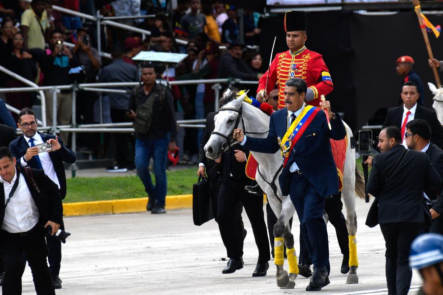 El presidente venezolano, Nicolás Maduro (c-frente), corre junto a un caballo y su jinete durante el desfile cívico militar llevado a cabo por los 213 años del Día de la Declaración de Independencia y Día de la Fuerza Armada Nacional Bolivariana de Venezuela, en Caracas, Venezuela, el 5 de julio de 2024. (Xinhua/Marcos Salgado)