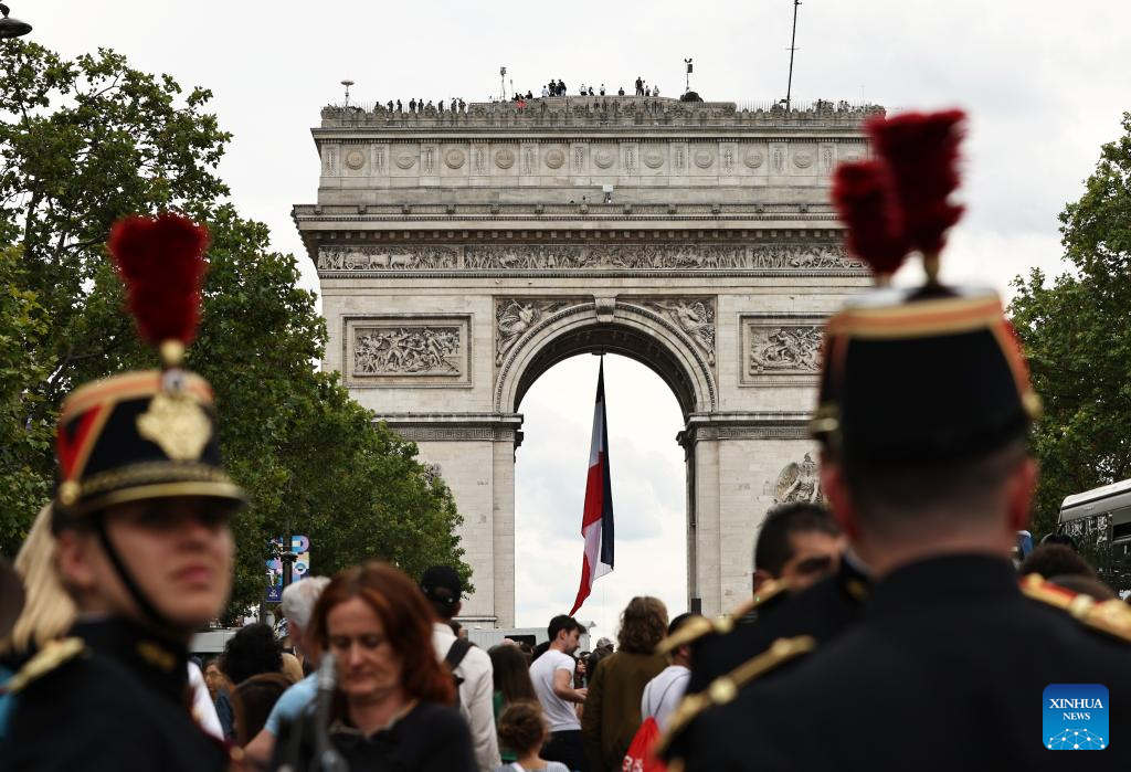 PARÍS, 14 julio, 2024 (Xinhua) -- Personas se reúnen para observar una presentación de aviones durante el desfile militar por el Día de La Bastilla, con el Arco del Triunfo en el fondo, en París, Francia, el 14 de julio de 2024. (Xinhua/Gao Jing) 