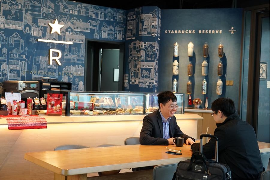 Consumidores charlan en una tienda de Starbucks con elementos de patrimonios culturales inmateriales locales en Beijing, capital de China, el 27 de noviembre de 2023. (Xinhua/Ren Chao)