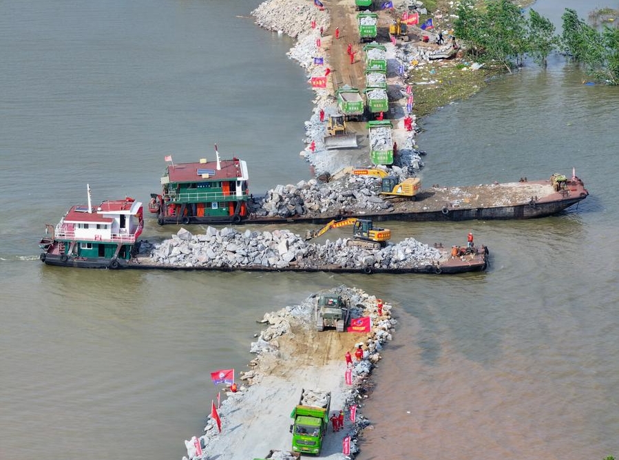 La foto aérea, tomada con un dron, muestra a los rescatistas trabajando para bloquear la ruptura del dique en el lago Dongting, en el distrito de Huarong, provincia central china de Hunan, el 8 de julio de 2024. (Xinhua/Chen Zeguo)