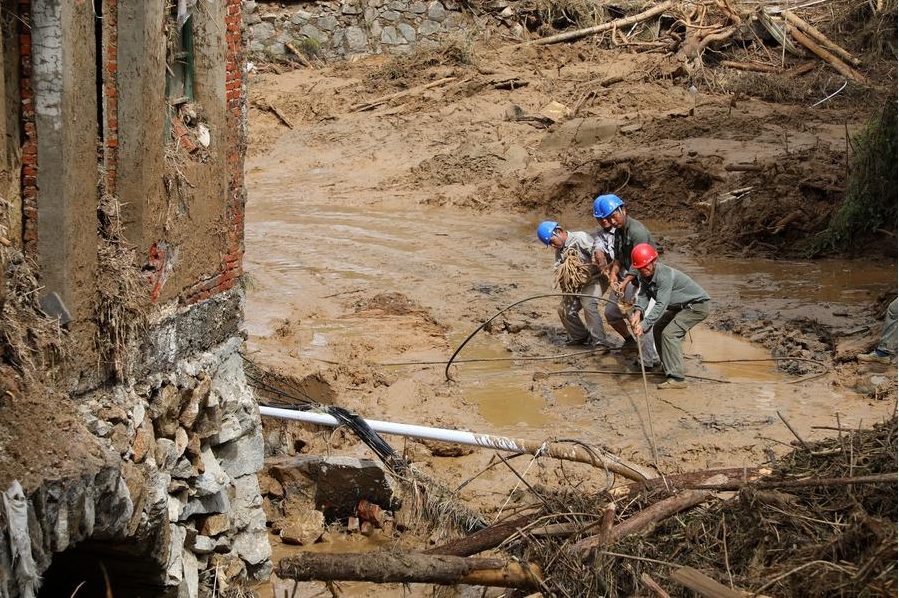 Operarios de una empresa de suministro de energía trabajan para restablecer la red eléctrica en el poblado de Zhoumensi, ciudad de Zixing, en la provincia central china de Hunan, el 29 de julio de 2024. (Xinhua/Cao Huabin)