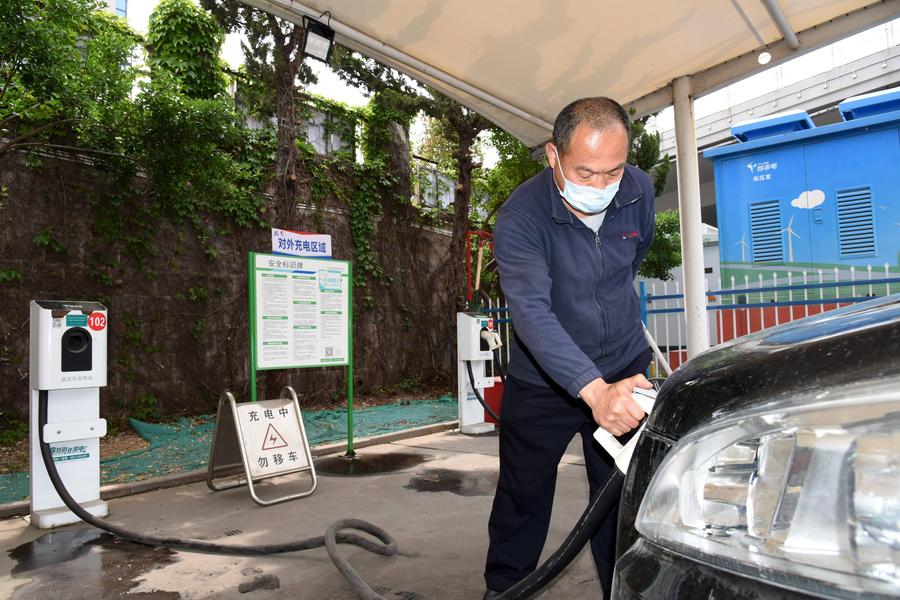 Imagen del 11 de mayo de 2022 de un conductor cargando su vehículo eléctrico en una estación de carga compartida de autobuses eléctricos, en Qingdao, en la provincia de Shandong, en el este de China. (Xinhua/Li Ziheng)