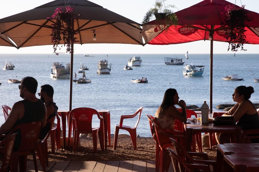 Imagen del 8 de agosto de 2023 de personas sentadas en un restaurante junto al mar, en Fortaleza, Brasil. (Xinhua/Wang Tiancong)