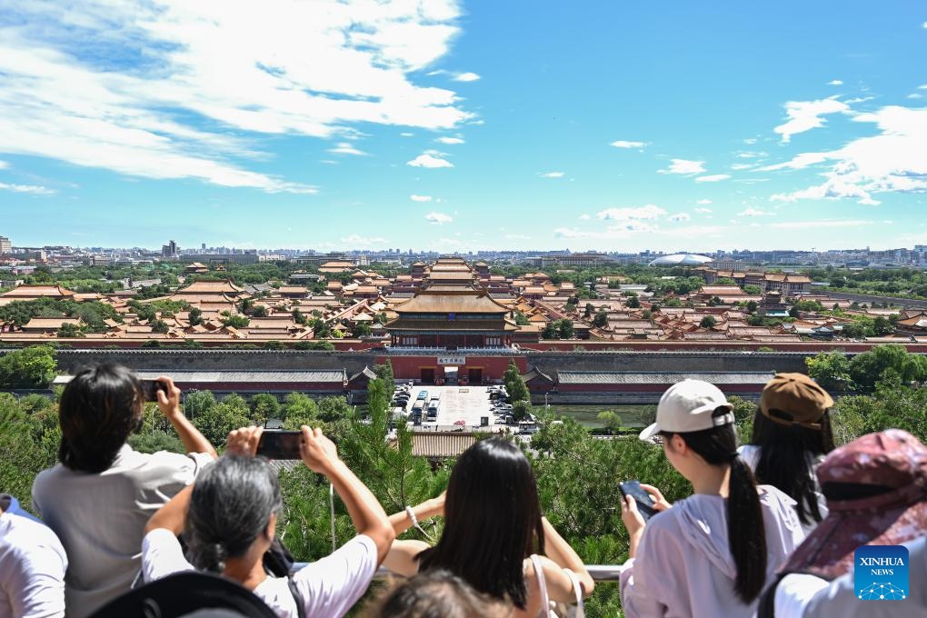 Turistas toman fotos del Museo del Palacio desde el Parque Jingshan en un día soleado de Beijing, 12 de agosto del 2024. (Foto: Xinhua)