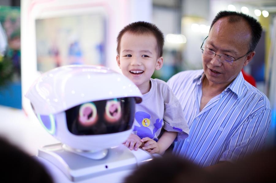 Un niño interactúa con un robot en la Exposicion Internacional de la Industria de Macrodatos de China 2023, en Guiyang, capital de la provincia suroccidental china de Guizhou, el 26 de mayo de 2023. (Xinhua/Liu Xu)