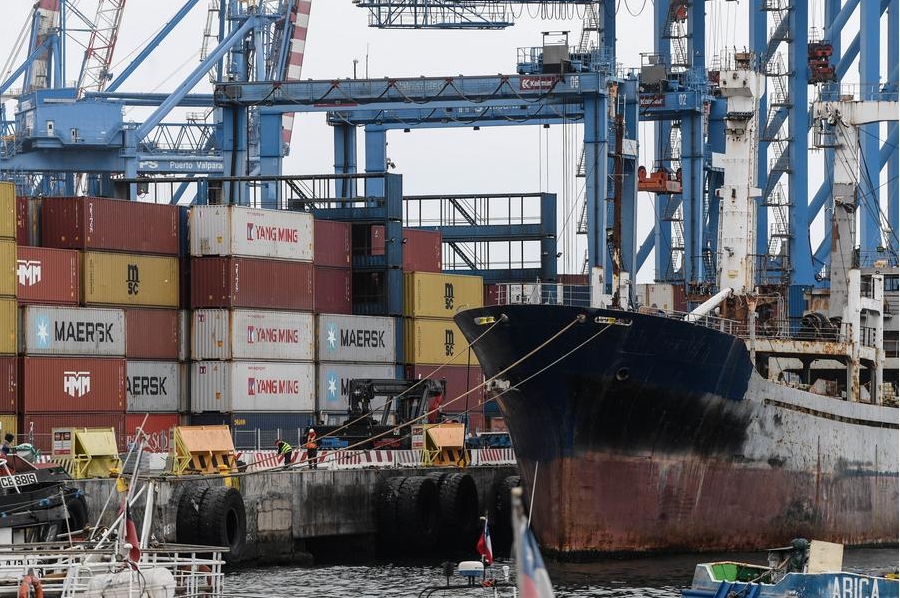 Imagen del 31 de julio de 2024 de trabajadores portuarios laborando frente a contenedores apilados en el Puerto de Valparaíso, en la ciudad de Valparaíso, Chile. (Xinhua/Jorge Villegas)