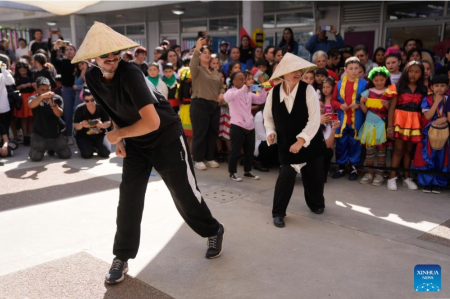 Imagen del 26 de septiembre de 2024 de maestros realizando una presentación durante el 20° aniversario de la denominación como República Popular China de una escuela primaria estatal en el barrio Casavalle, en Montevideo, capital de Uruguay. Con coloridas danzas y presentaciones musicales, cientos de niños uruguayos celebraron el 20° aniversario de la denominación como República Popular China de una escuela primaria estatal de Montevideo, que tiene el apoyo de la Embajada china. (Xinhua/Nicolás Celaya)