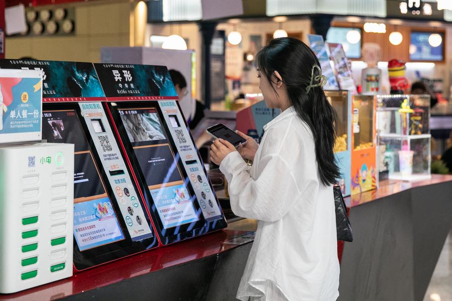 Una espectadora saca entradas de una máquina de autoservicio en un cine de Beijing, capital de China, el 21 de agosto de 2024. (Xinhua/Chu Jiayin)