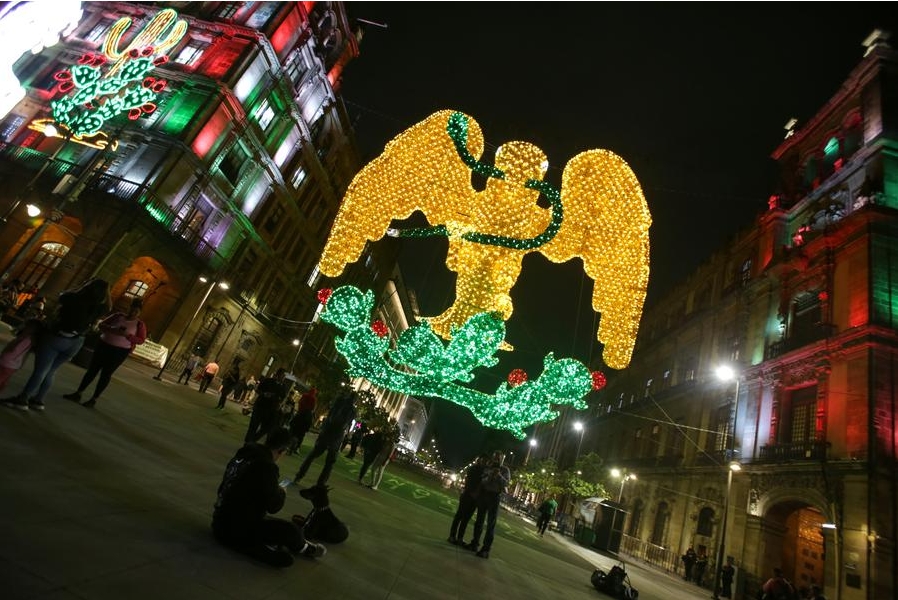 Imagen del 4 de septiembre de 2024 de personas observando el alumbrado decorativo colocado con motivo del 214º Aniversario de la Independencia de México, en el Zócalo de la Ciudad de México, capital de México. (Xinhua/Francisco Cañedo) 